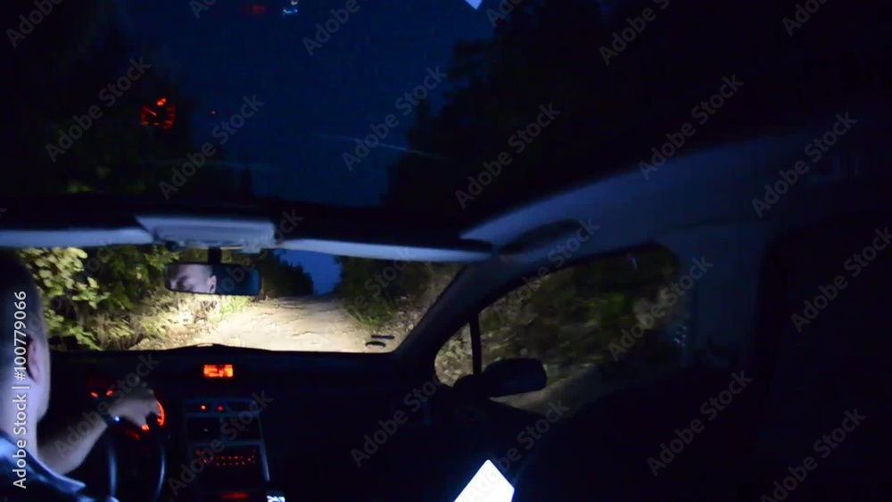 man drive in a car at nigt, interior illuminated with laptop computer man drive in a car at nigt, interior illuminated with laptop computer