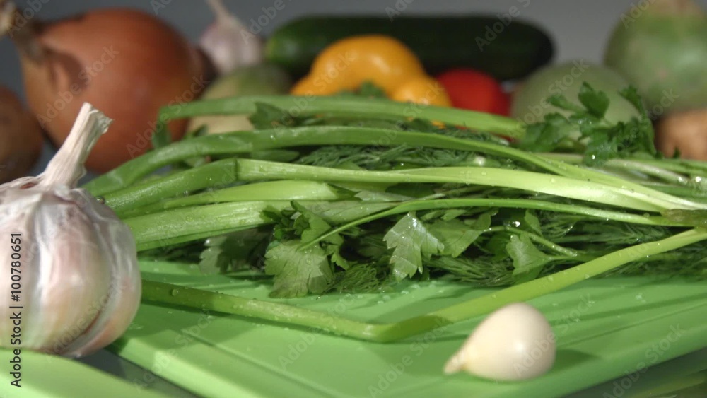 A beam of green onions, dill and parsley. Close-up. Slow motion. A beam of green onions, dill and parsley. Close-up. Slow motion.