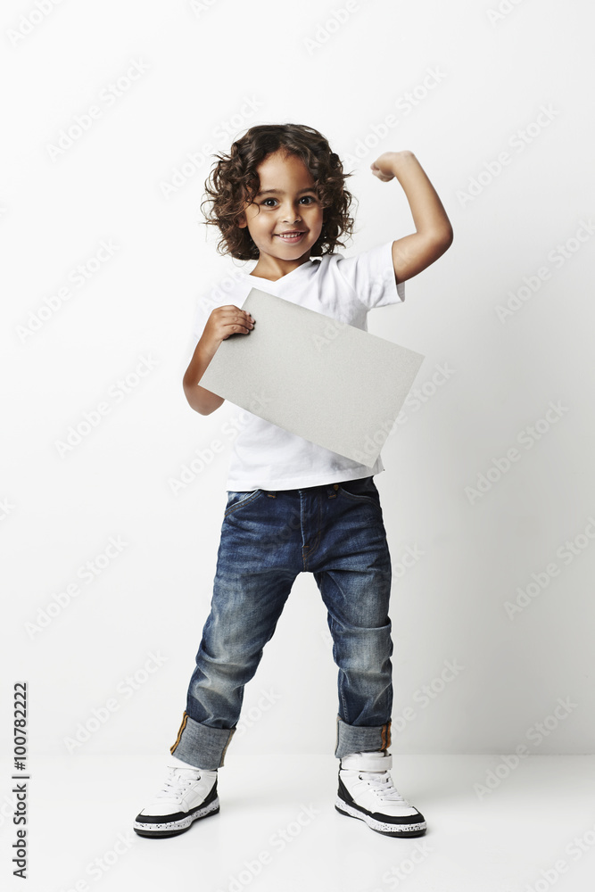 Cool young kid with blank message flexing muscle, portrait