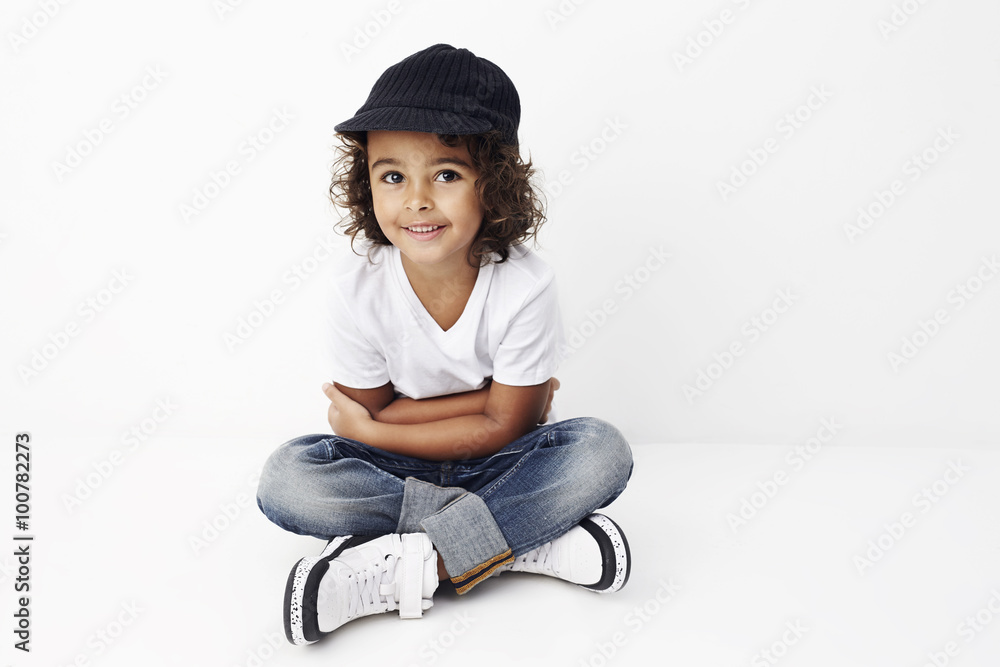 Happy young boy in cool clothes sitting in studio Happy young boy in cool clothes sitting in studio