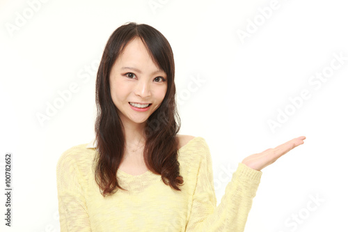 young Japanese woman presenting and showing something 