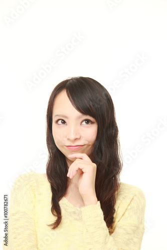 young Japanese woman thinks about something