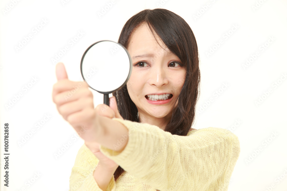 shocked young woman looking through a magnifying glass her nails shocked young woman looking through a magnifying glass her nails