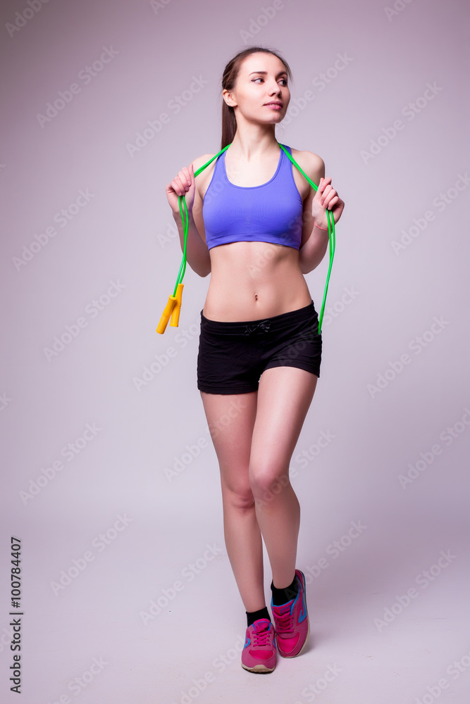 Young fitness woman with healthy sporty figure with skipping rope Young fitness woman with healthy sporty figure with skipping rope