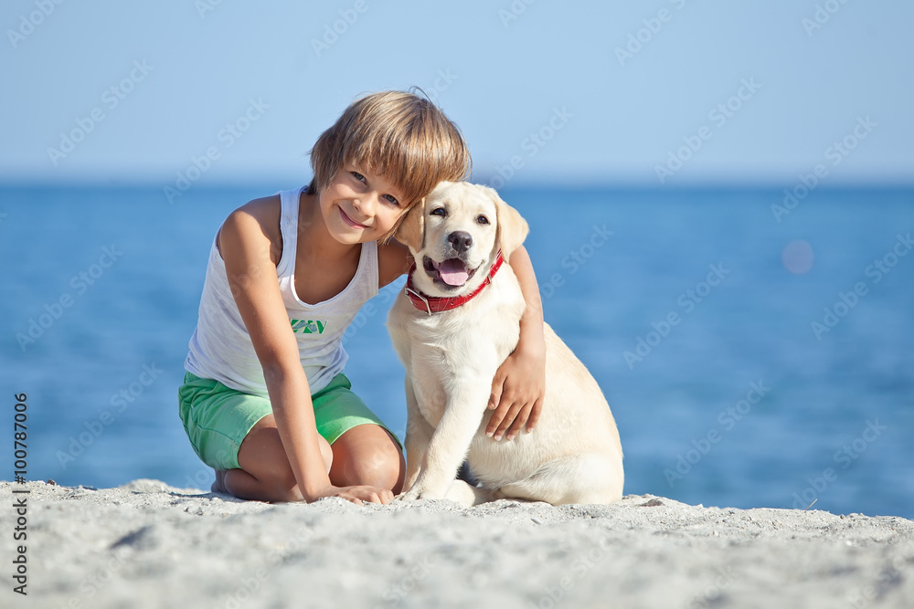 Happy kid with a dog on the beach Happy kid with a dog on the beach