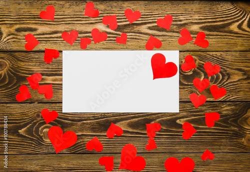 Holiday/romantic/wedding/valentine Day background with small paper hearts and message card on wooden table.