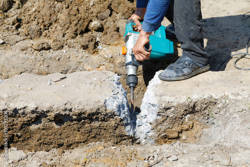 Worker hammer smashes the concrete foundation photo