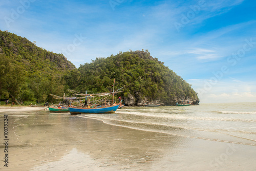 Samphraya Beach, fishing boat parked on beach, background is blue sky © dewspliff