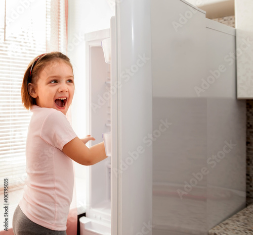 Happy child playing with fridge
