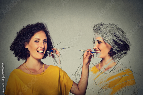 Attractive young woman drawing a picture portrait sketch of herself photo