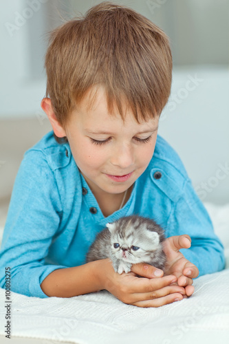 Happy kid are playing with kitten 