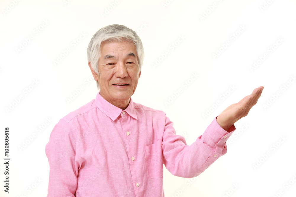 senior Japanese man presenting and showing something senior Japanese man presenting and showing something