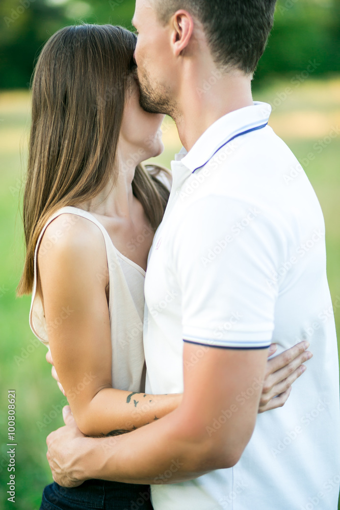 Beautiful young loving couple hugging in nature. The concept of good mood Beautiful young loving couple hugging in nature. The concept of good mood