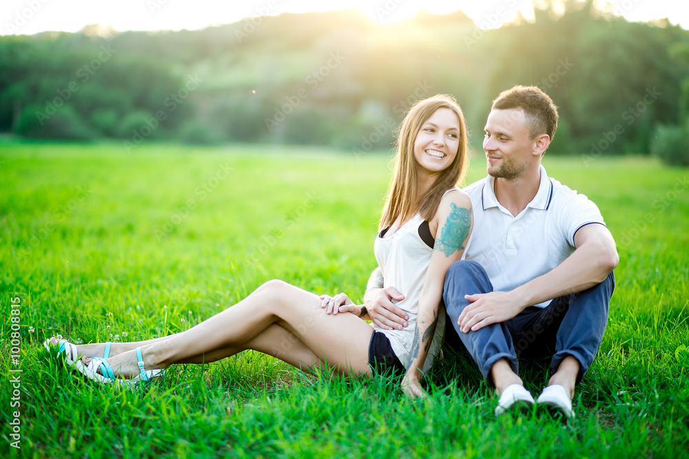 Young couple in love outdoor.Stunning sensual outdoor portrait of young stylish fashion couple posing in summer in field Young couple in love outdoor.Stunning sensual outdoor portrait of young stylish fashion couple posing in summer in field
