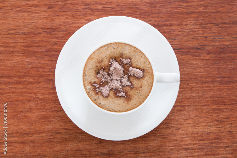 A cup of cappuccino at the wooden table A cup of cappuccino at the wooden table