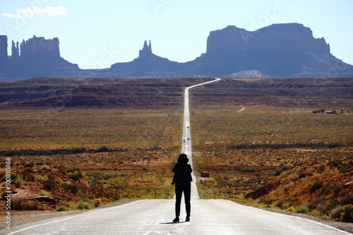 Tourist photographing the famous view from road US 163 in Monument Valley Park, Utah, USA photo