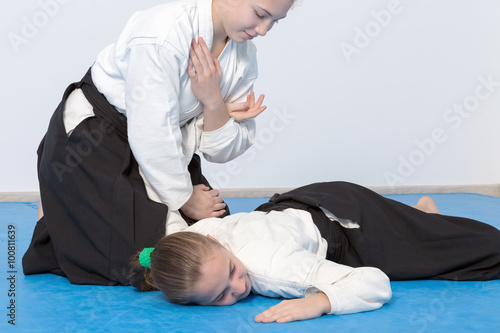 Two girls in black hakama practice Aikido