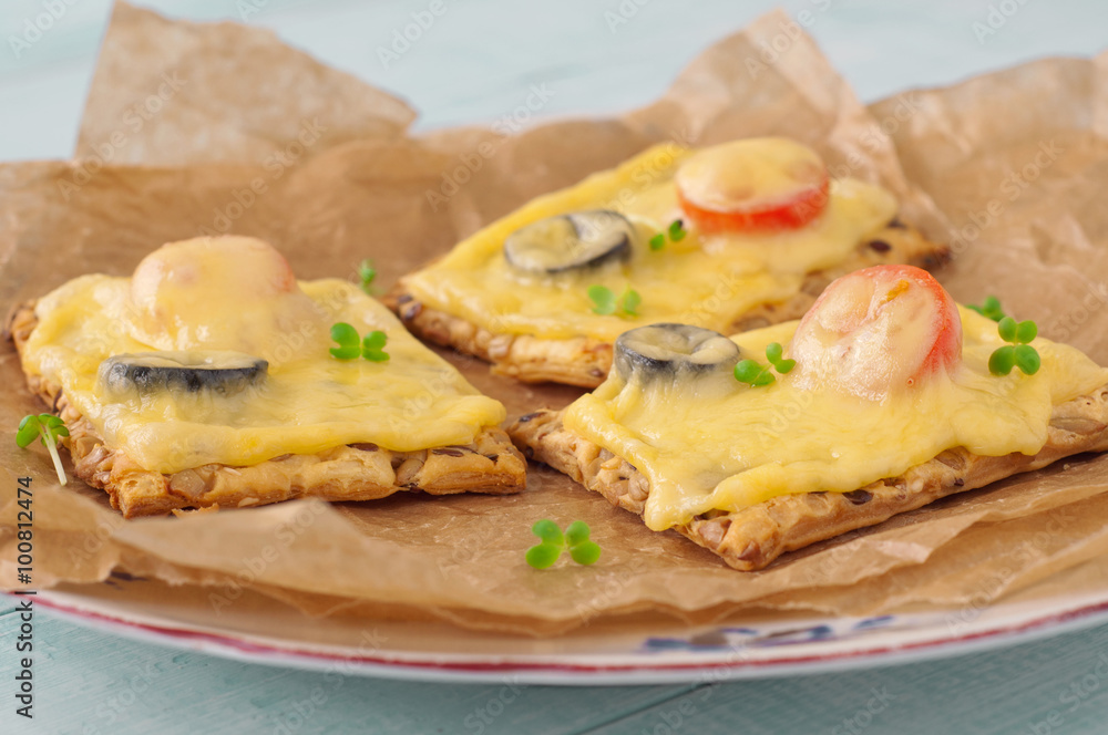 Closeup canapes with melted cheese, cherry tomatoes and olives Closeup canapes with melted cheese, cherry tomatoes and olives