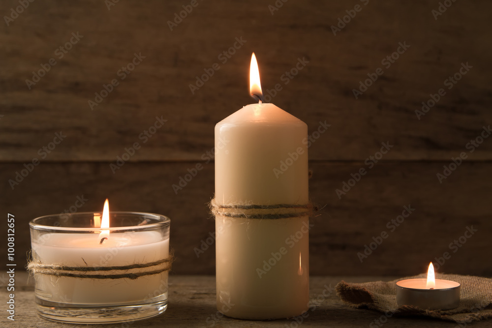 light burning brightly candles on old wooden background. Spa, meditation, ritual, flavored. light burning brightly candles on old wooden background. Spa, meditation, ritual, flavored.