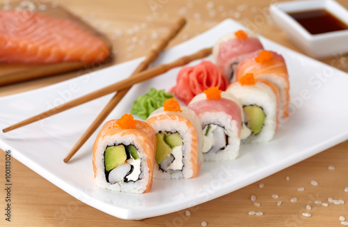 Rainbow dragon sushi roll with salmon, avocado, soft cheese, cucumber and tobiko caviar