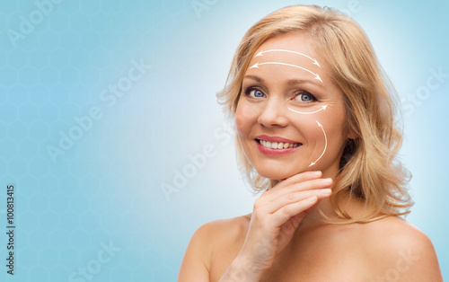 smiling woman with bare shoulders touching face photo