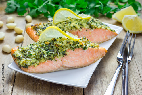 Baked salmon with macadamia-cilantro crust on a white plate photo