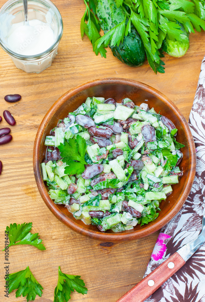 Fresh salad of cucumbers, greens and red beans with sour cream, view from above Fresh salad of cucumbers, greens and red beans with sour cream, view from above