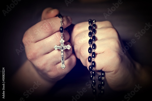 Canvas Print Caucasian person's hands tighten a Christian rosary for prayer