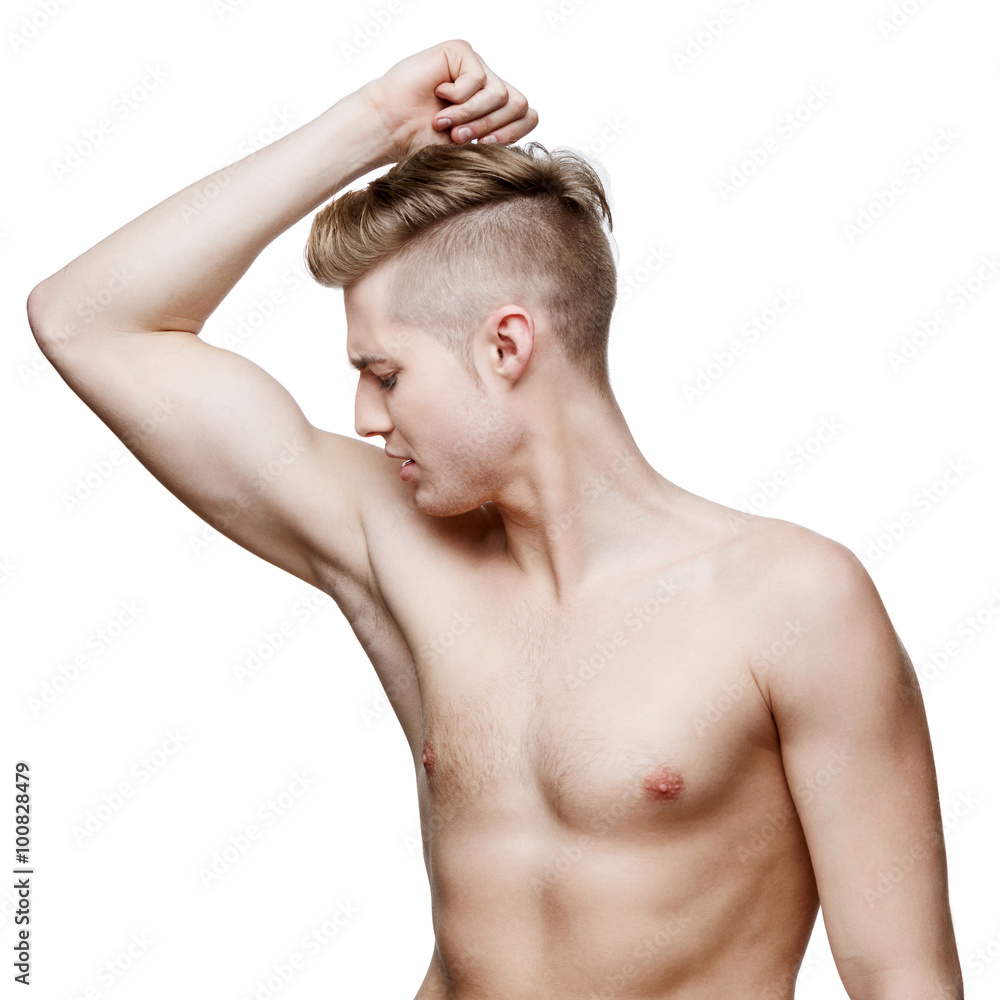 Handsome young man sniffing his armpit