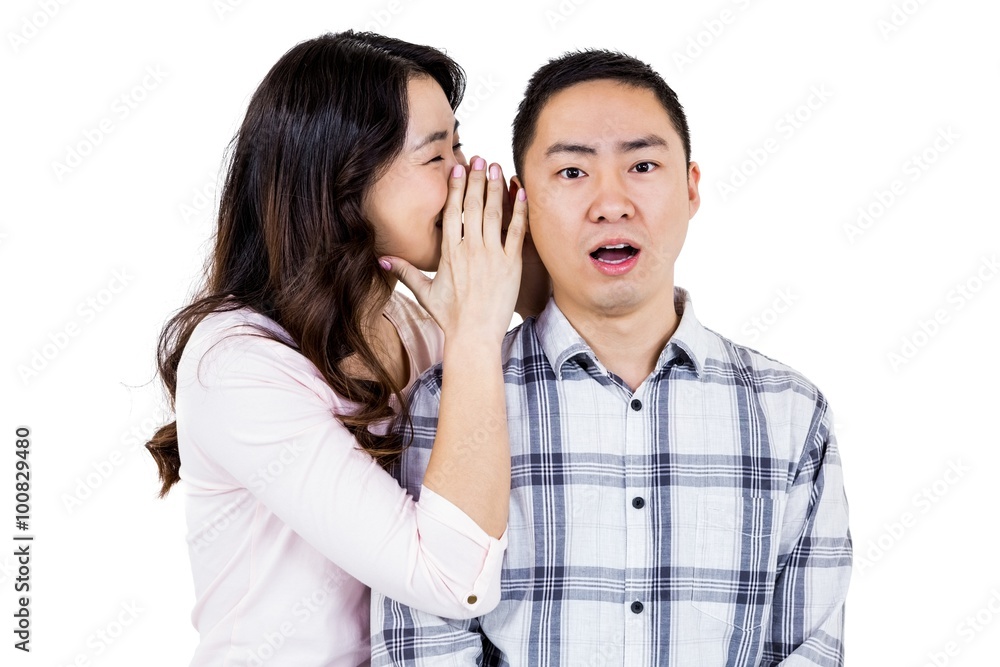 Woman whispering secret to husband Woman whispering secret to husband