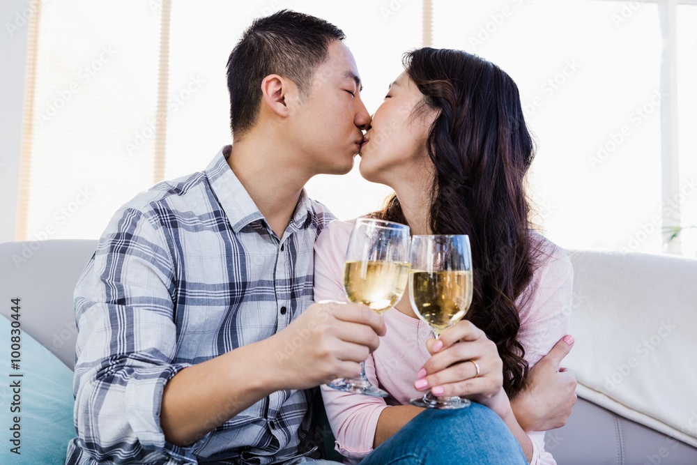 Young couple kissing and holding wineglasses Young couple kissing and holding wineglasses