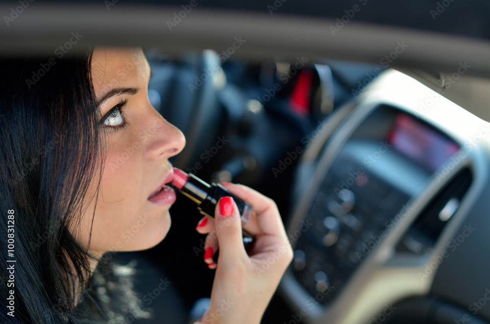 young woman in the car applying lipstick young woman in the car applying lipstick