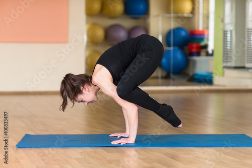 Young sports woman practicing yoga Pose. Indoor gym.