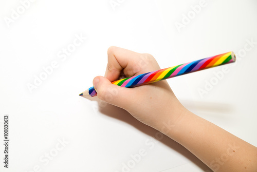 Kid's rigth hand holding a pencil on over white photo