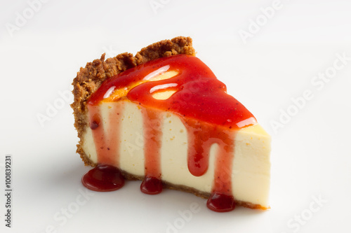 Slice cheesecake with  strawberry sauce on white background photo