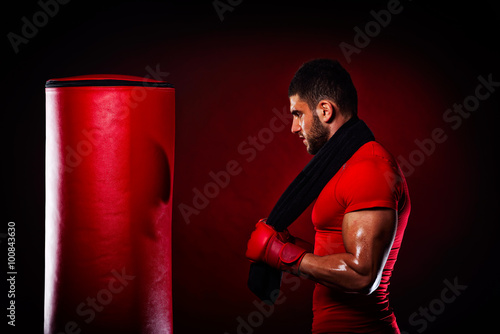 young man standing by  boxing bag photo