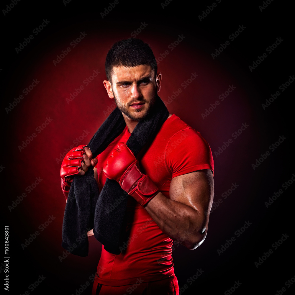 young man standing by  bag boxing in studio
