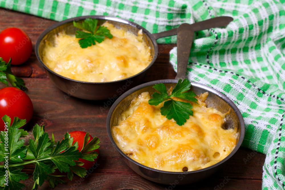 French cuisine. Сhicken with mushrooms baked with cheese in a cocotte French cuisine. Сhicken with mushrooms baked with cheese in a cocotte