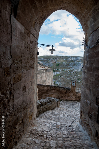 Passage with lantern leading to view of ancient caverns of Sassi photo