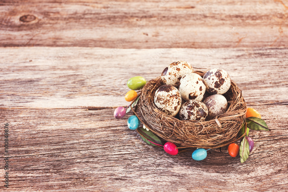 Easter quail eggs in small nest on wooden background. Decorate, toned, soft focus Easter quail eggs in small nest on wooden background. Decorate, toned, soft focus