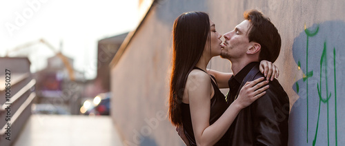 Man hugging and kissing girlfriend in the city letterbox © patronestaff