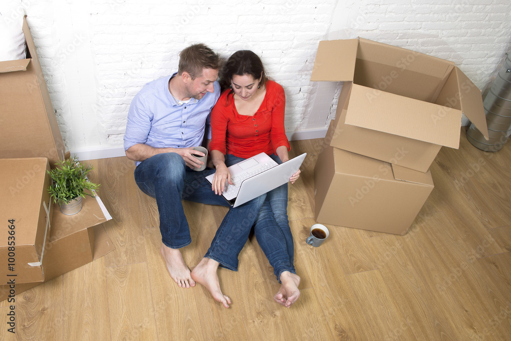 happy American couple sitting on floor kissing celebrating movin happy American couple sitting on floor kissing celebrating movin