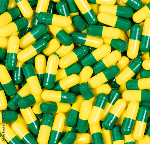 Medication capsules in green and yellow colors