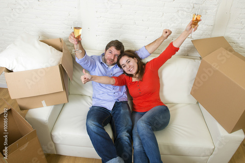  young happy American couple lying on couch together celebrating moving to new house unpacking cardboard boxes © Wordley Calvo Stock