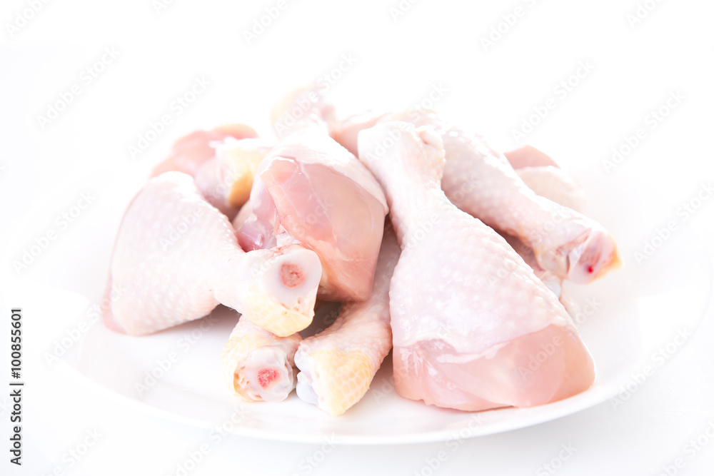 raw chicken drumsticks on white background