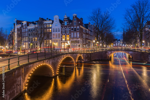 Obraz na płótnie Night view over Amsterdam canals and bridges, with lights and their trails w salonie