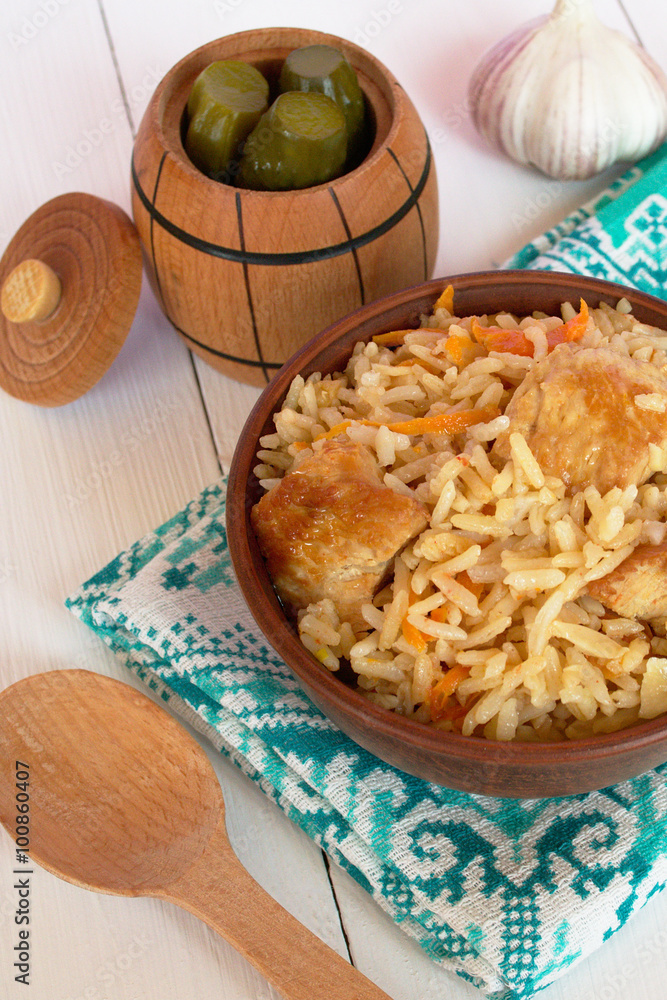 Pilaf with meat in a bowl and towel on white background Pilaf with meat in a bowl and towel on white background