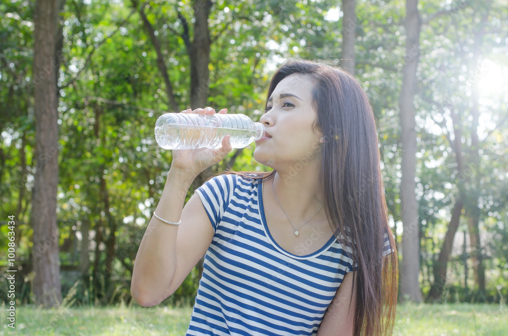 Beautiful Asian woman drinking water in park Beautiful Asian woman drinking water in park