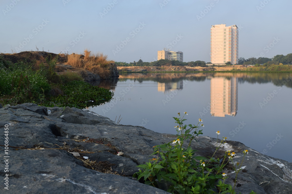 Fototapeta premium river bank with the building reflect on the water surface