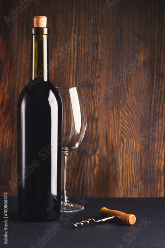 Billede på lærred Full bottle of wine, empty glass and corkscrew